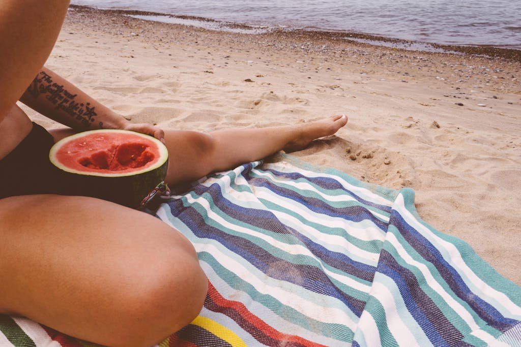 Person Eating Watermelon by the Beach